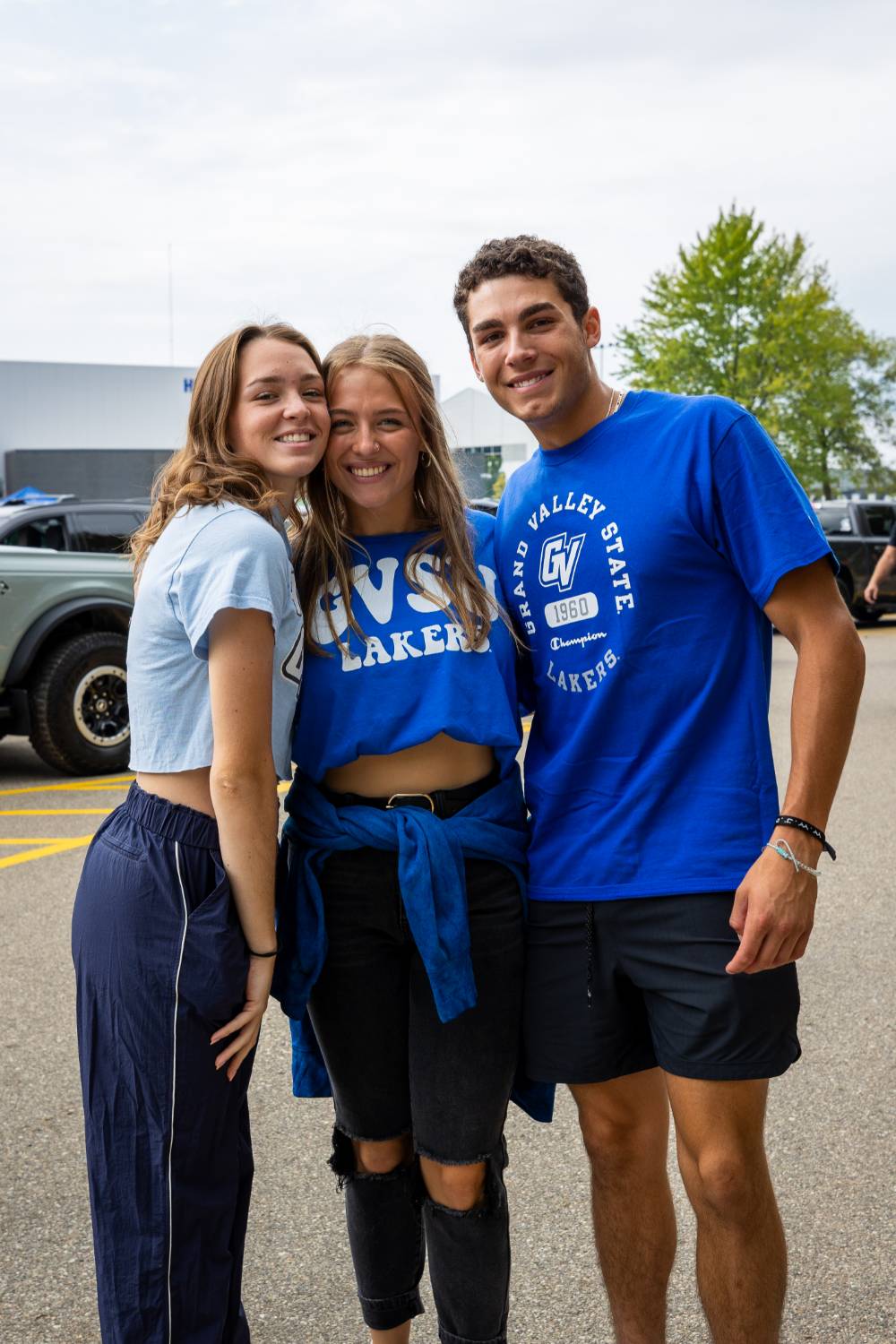 Three students pose for a picture during tailgate.